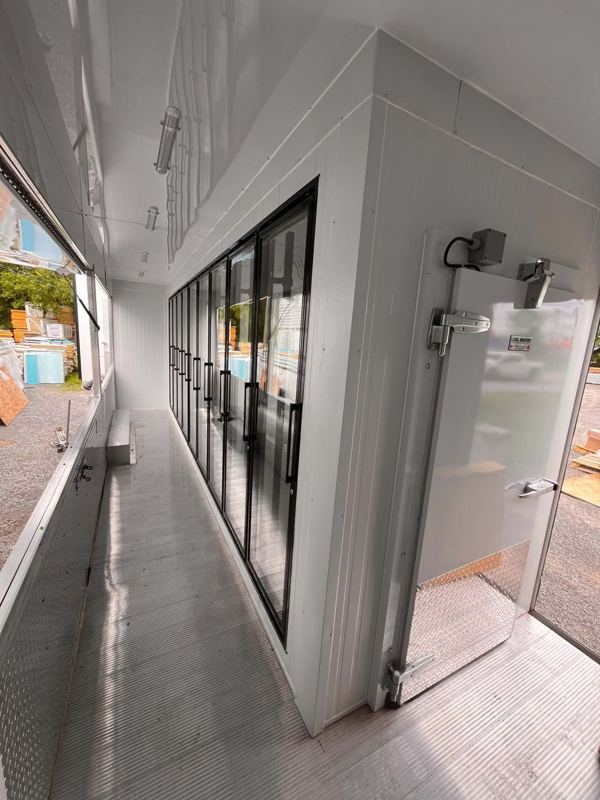 Allée de service le long des portes vitrées réfrigérées dans une remorque