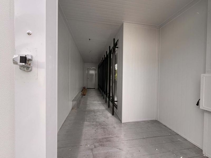 Intérieur d’une remorque réfrigérée en panneaux isolés blancs, vue vers la porte du fond