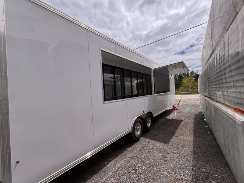 Remorque blanche aménagée avec comptoir de service et portes vitrées réfrigérées