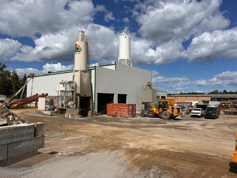 Usine avec silos, murs extérieurs recouverts de panneaux isolés gris et blancs